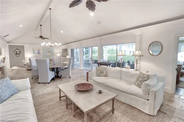 a living room with furniture a chandelier and a large window