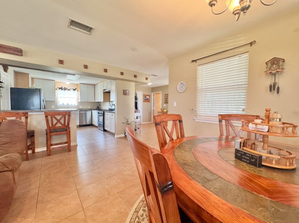 2334 County Road 464 Elgin, TX 78621 - Photo 12 of 39 Dining area with light tile patterned floors and a chandelier