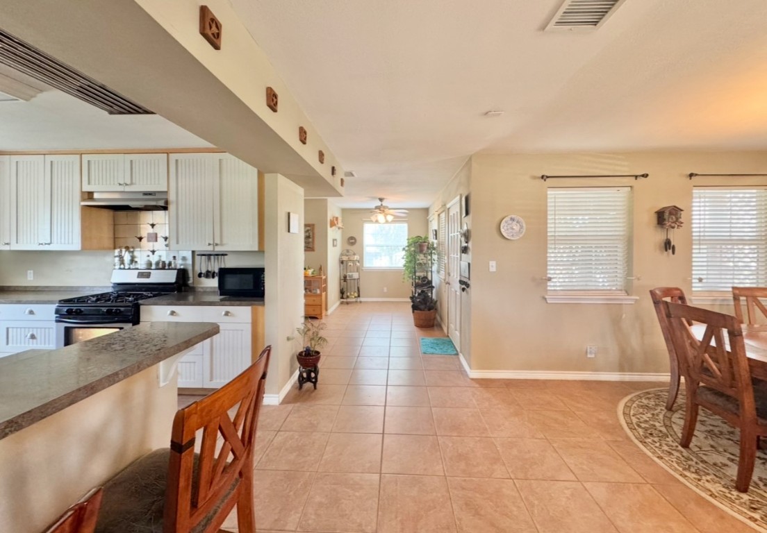 2334 County Road 464 Elgin, TX 78621 - Photo 17 of 39 a kitchen with stainless steel appliances kitchen island granite countertop a table chairs in it and a window
