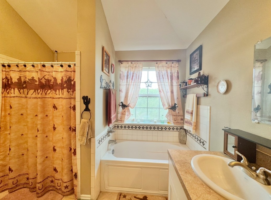 2334 County Road 464 Elgin, TX 78621 - Photo 24 of 39 a bathroom with a tub sink and mirror