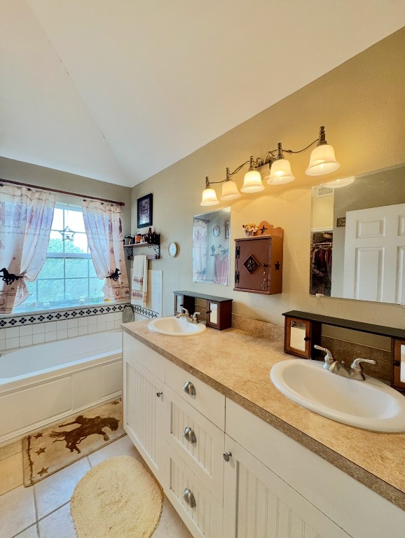 2334 County Road 464 Elgin, TX 78621 - Photo 25 of 39 Full bath with lofted ceiling, double vanity, a bath, and tile patterned flooring