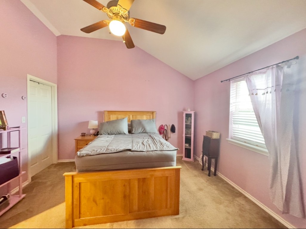 2334 County Road 464 Elgin, TX 78621 - Photo 28 of 39 a bedroom with a bed and a chandelier