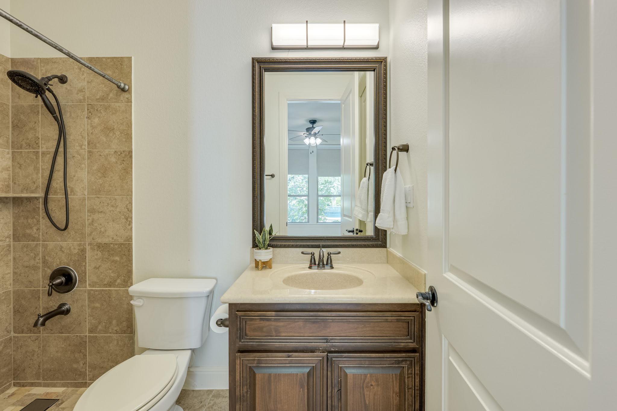 11612 Shoreview Overlook Austin, TX 78732 - Photo 30 of 40 A well-appointed bathroom features a single vanity with stone counters and a tiled shower.