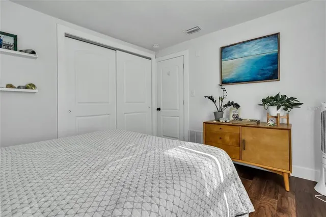 a bedroom with a bed and a potted plant