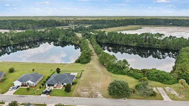 an aerial view of lake and residential houses with outdoor space