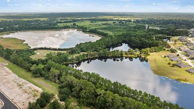 an aerial view of residential houses with outdoor space and lake view