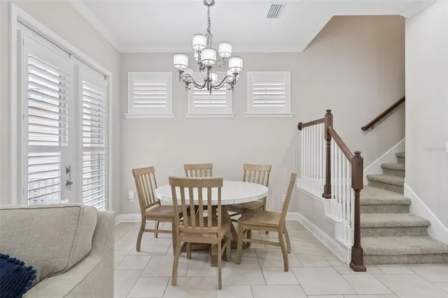 a kitchen with stainless steel appliances kitchen island granite countertop a dining table chairs and a refrigerator