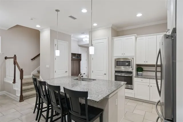 a kitchen with stainless steel appliances granite countertop a sink stove and refrigerator