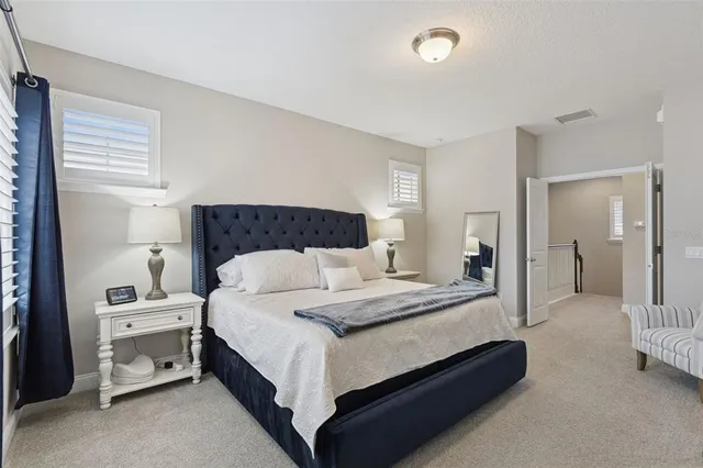 a spacious bedroom with a bed and a flat screen tv