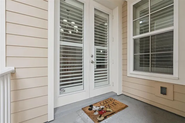 a living room with patio furniture and a floor to ceiling window