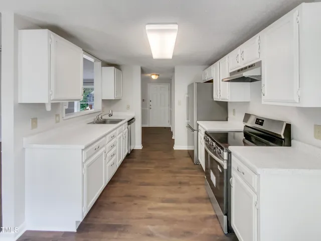 a kitchen with stainless steel appliances a sink stove top oven and cabinets