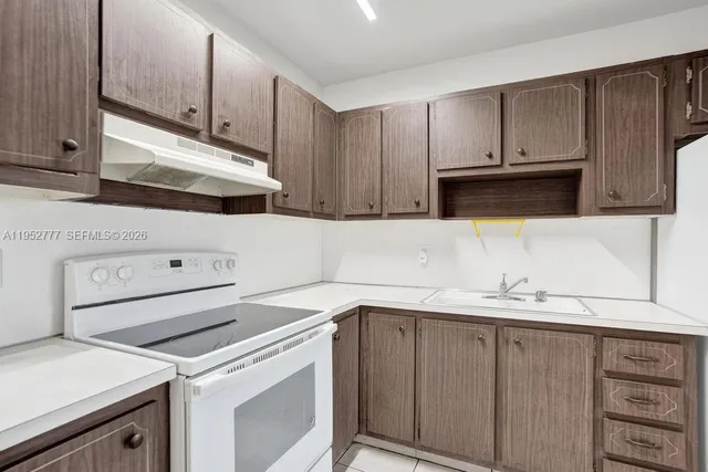 a kitchen with a sink a stove and a refrigerator