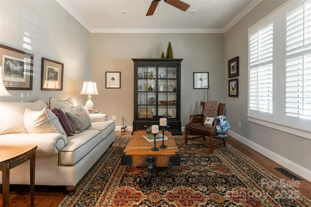 a view of staircase with lots of frames on wall and wooden floor