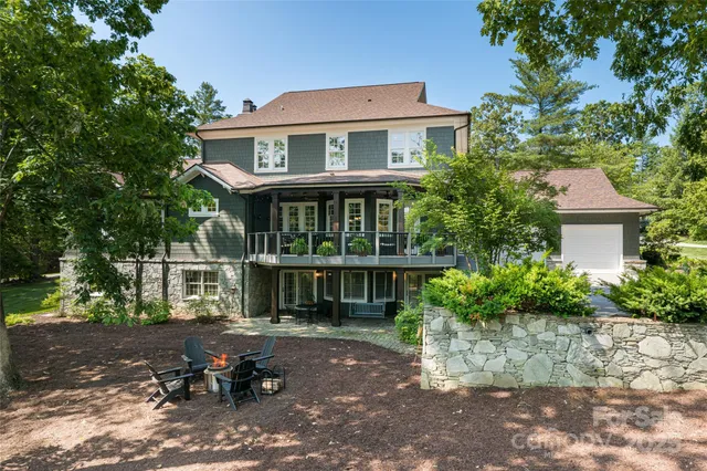 a front view of a house with a yard and large trees