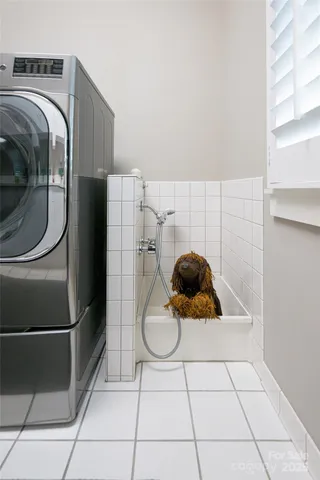 a bathroom with a tub a window and glass door shower
