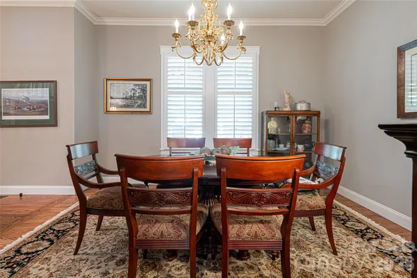 a kitchen with stainless steel appliances kitchen island granite countertop a stove a refrigerator a kitchen island a dining table and chairs with wooden floor