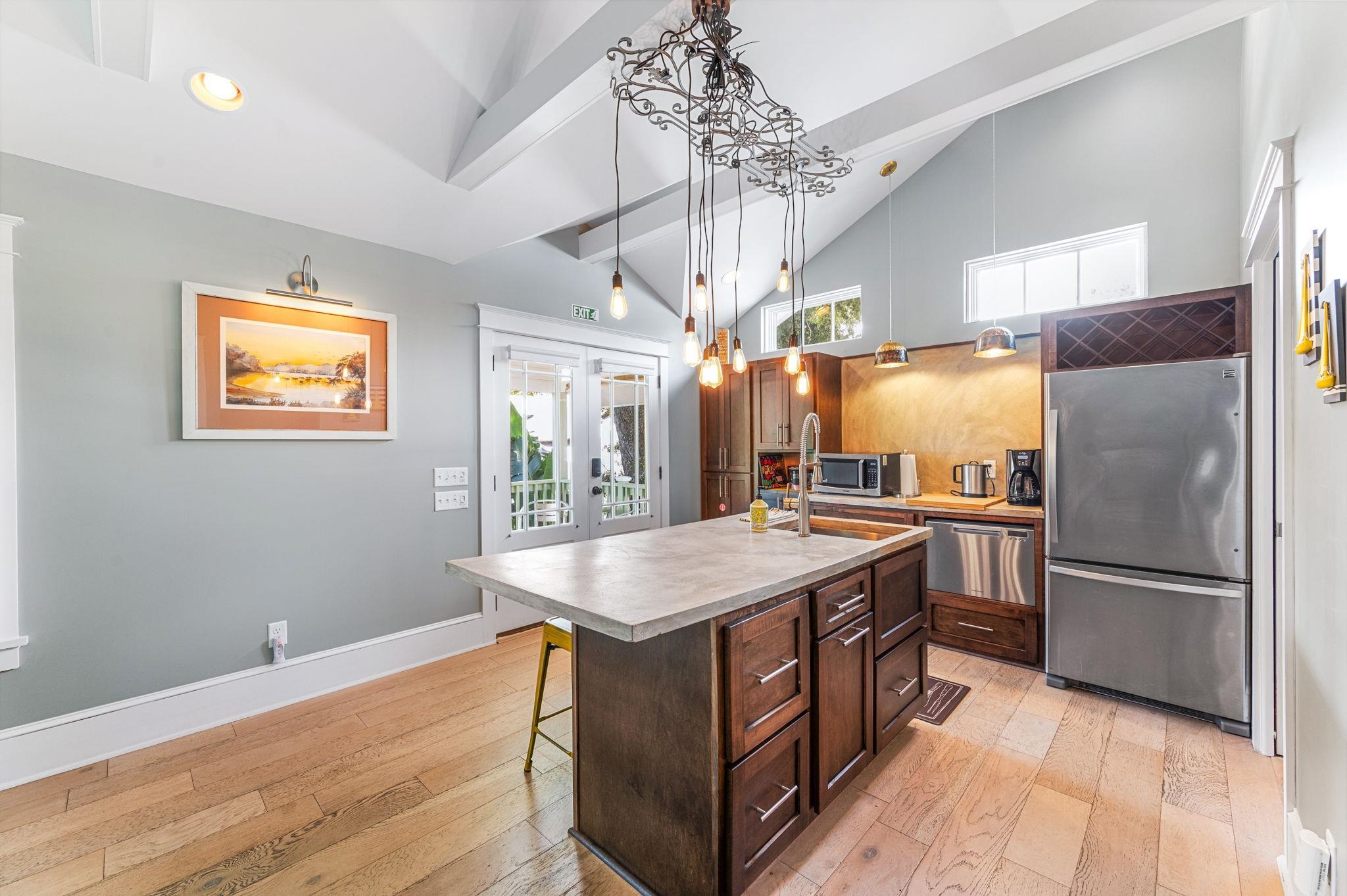 20 Riberia Street St. Augustine, FL 32084 - Photo 37 of 56 a kitchen with stainless steel appliances granite countertop a refrigerator a sink dishwasher a stove and a dining table with wooden floor