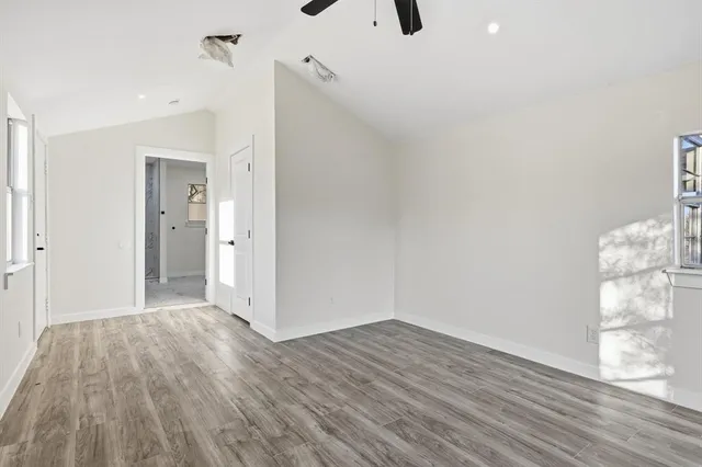 a view of a big room with wooden floor and windows
