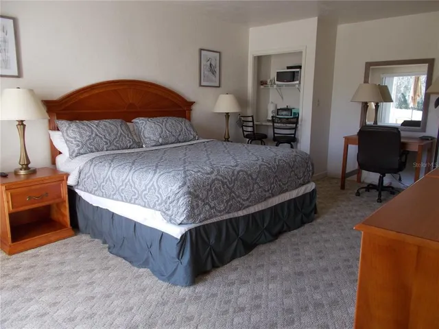 a bedroom with a bed and dresser with mirror