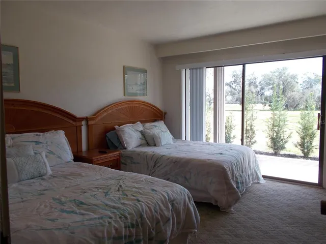 a bedroom with two beds and a large window