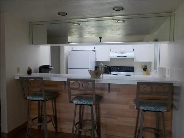 a kitchen with a sink a table and chairs in it