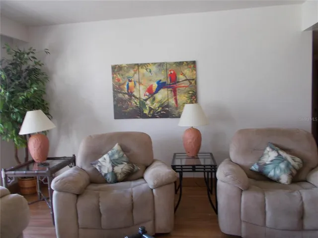 a living room with furniture and a painting on the wall