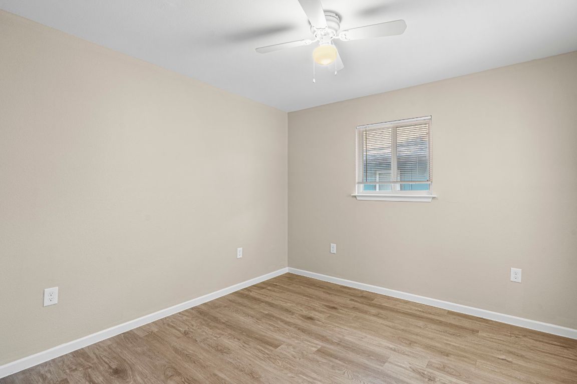 7307 Thannas Way Austin, TX 78744 - Photo 13 of 20 an empty room with wooden floor and windows