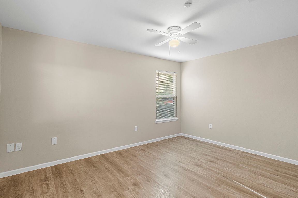 7307 Thannas Way Austin, TX 78744 - Photo 16 of 20 wooden floor in an empty room with a window
