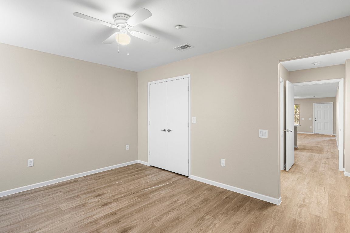 7307 Thannas Way Austin, TX 78744 - Photo 17 of 20 an empty room with wooden floor and a ceiling fan