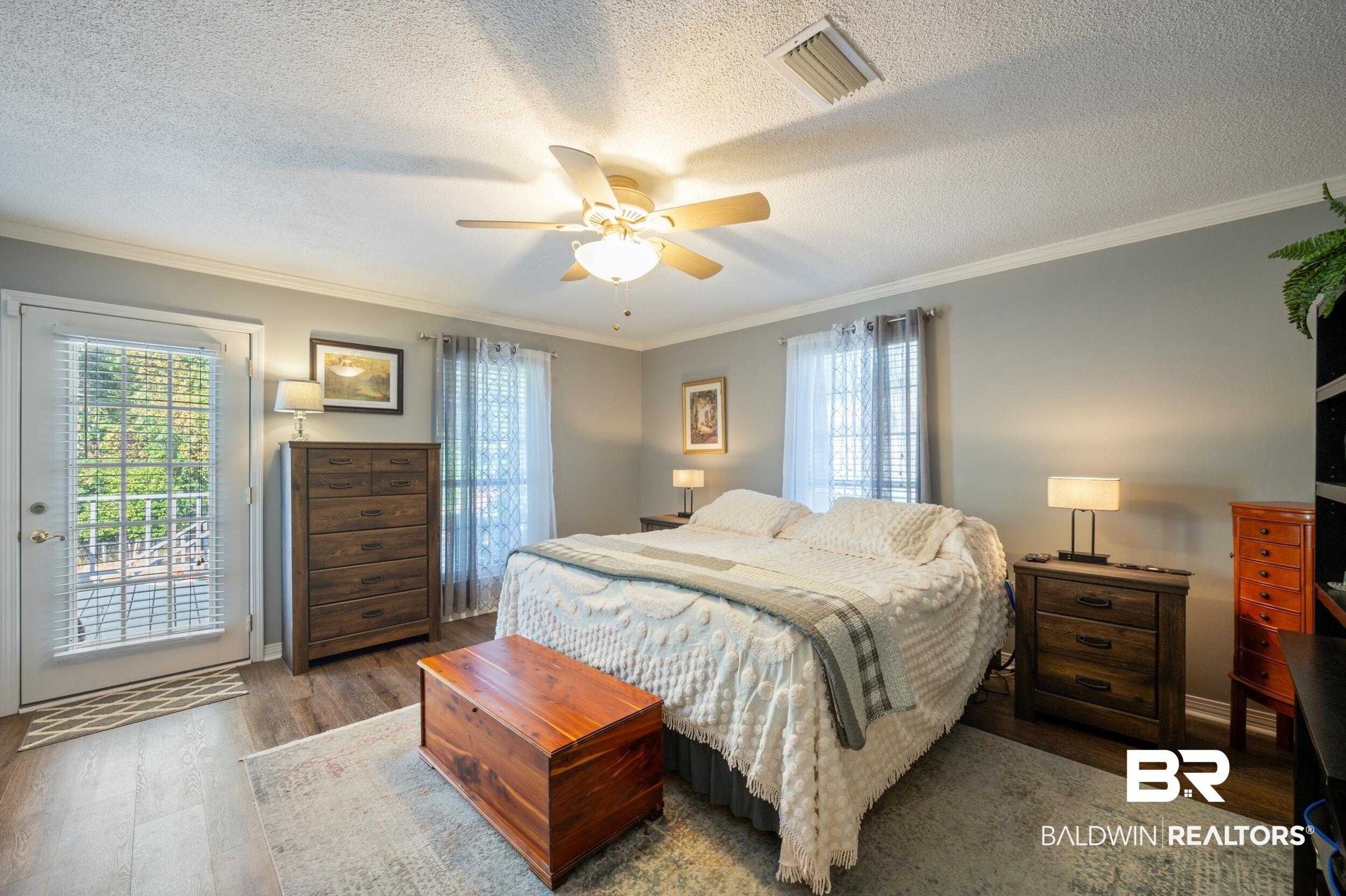 550 Norwood Road Monroeville, AL 36460 - Photo 23 of 46 Bedroom featuring access to outside, crown molding, dark wood-style flooring, ceiling fan, and a textured ceiling
