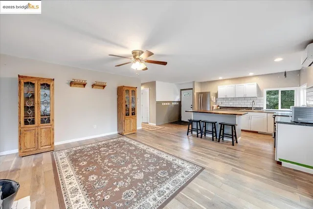 a view of a livingroom with furniture a ceiling fan and wooden floor