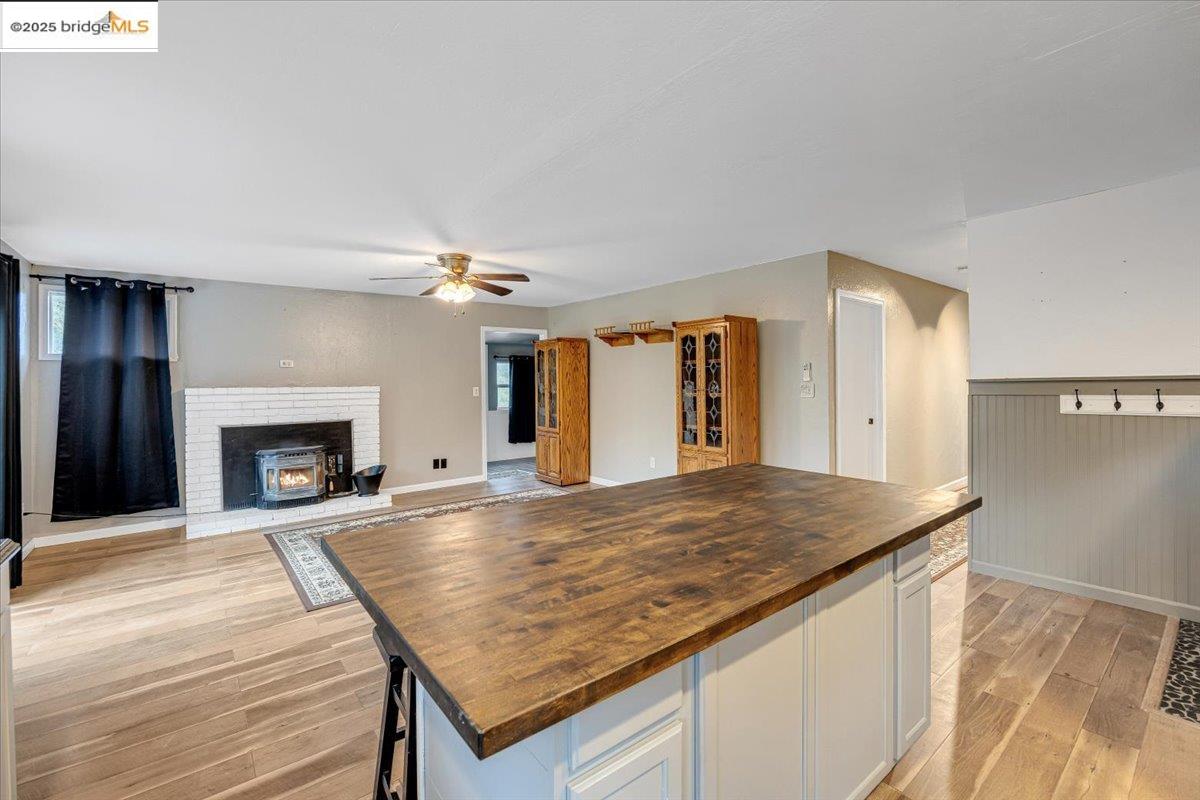 21980 Montgomery Road Sonora, CA 95370 - Photo 52 of 52 Kitchen featuring butcher block counters, a center island, light wood finished floors, open floor plan, and wainscoting