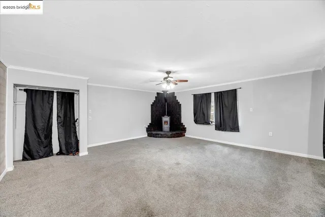 an empty room with closet and a ceiling fan