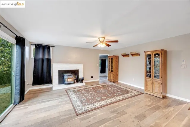 a view of an empty room with window and fire place