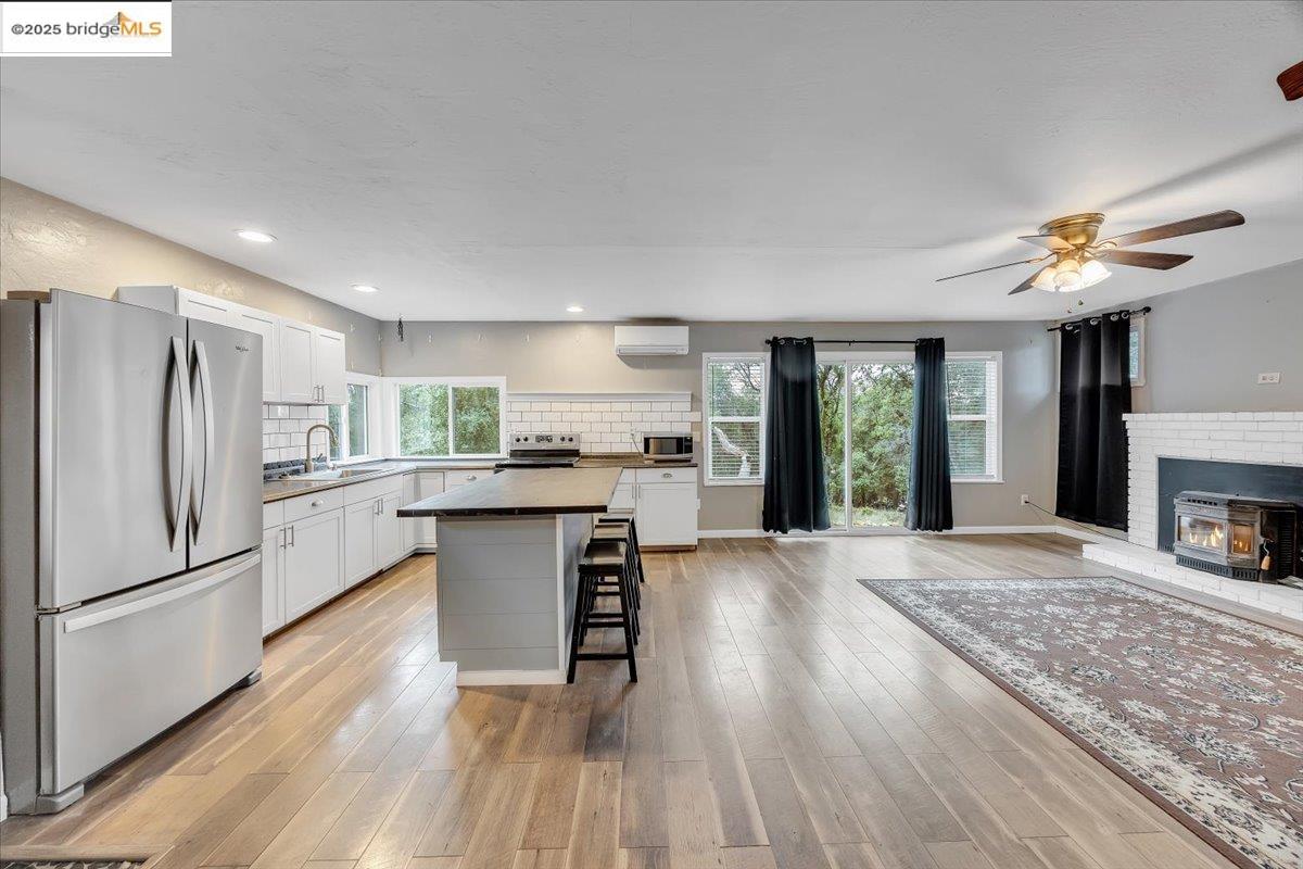 21980 Montgomery Road Sonora, CA 95370 - Photo 7 of 52 Kitchen featuring appliances with stainless steel finishes, white cabinetry, a center island, a breakfast bar, and recessed lighting