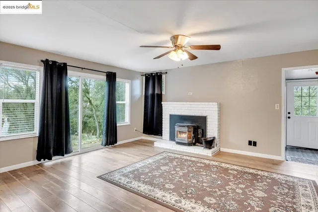 a view of an empty room with window and fire place
