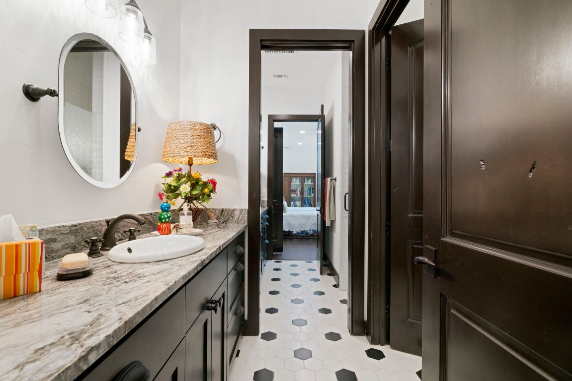 4073 Bell Springs Road Dripping Springs, TX 78620 - Photo 31 of 38 a bathroom with a granite countertop sink a toilet and shower