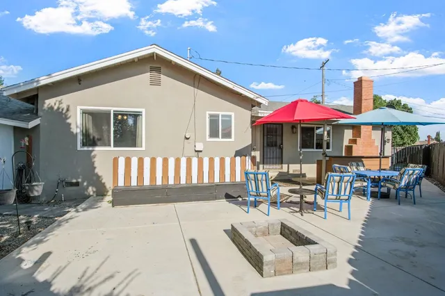 a view of a house with backyard and sitting area