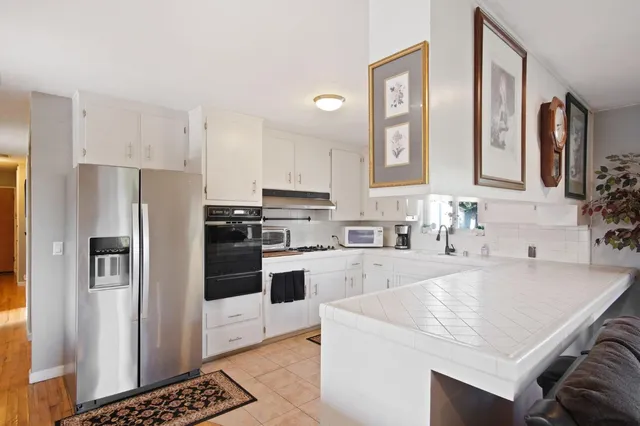 a kitchen with granite countertop a refrigerator stove and sink