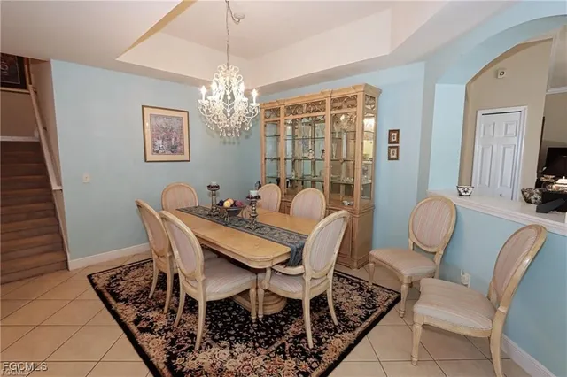 a view of a dining room with furniture a chandelier and wooden floor
