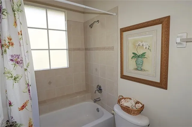 a bathroom with a bathtub a window and a shower