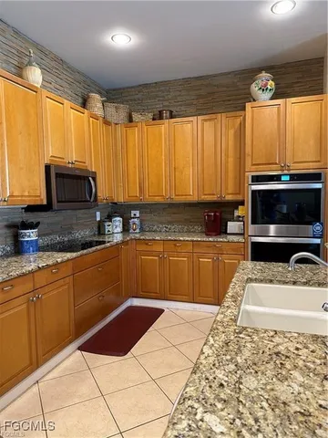 a kitchen with granite countertop a sink and a stove top oven