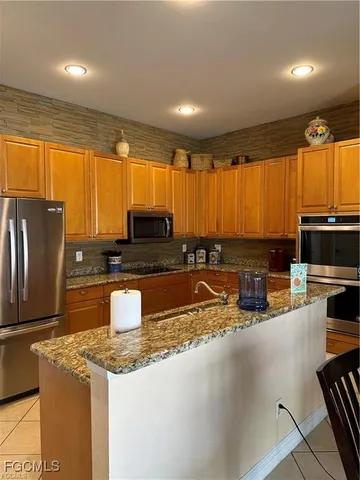 a kitchen with stainless steel appliances granite countertop a sink a stove and a refrigerator