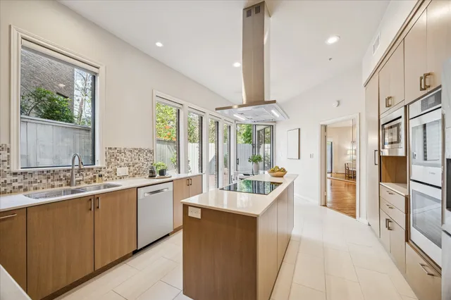 a large kitchen with a large window and stainless steel appliances