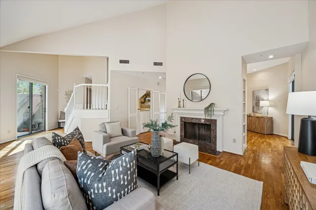 a living room with furniture a fireplace a rug and a large window