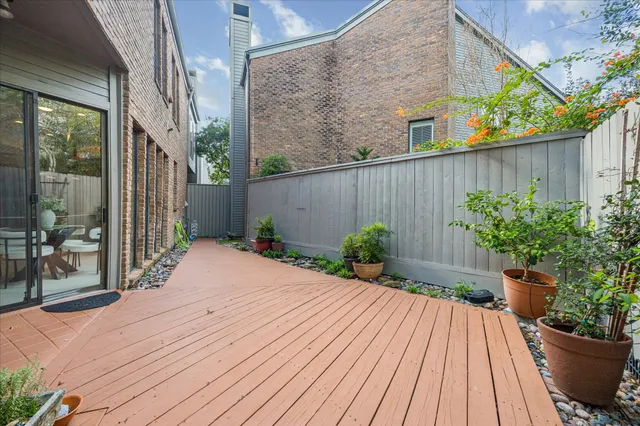 a view of a brick house with potted plants and wooden walls