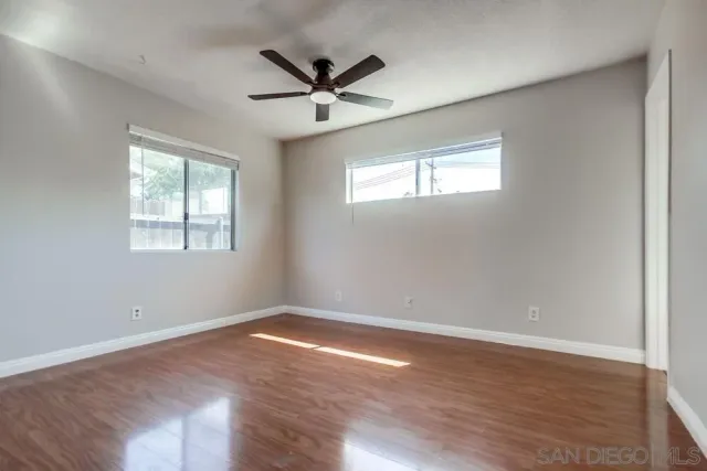 a view of a big room with wooden floor closet and windows