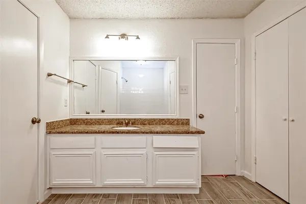 a bathroom with a granite countertop sink and a mirror