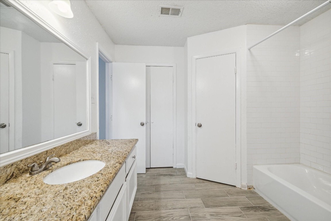 5302 Oaklynn Drive Spring, TX 77373 - Photo 13 of 15 a bathroom with a granite countertop sink and a bathtub