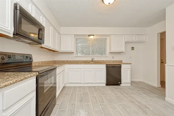 a kitchen with stainless steel appliances granite countertop a stove a sink dishwasher and a refrigerator with wooden cabinets